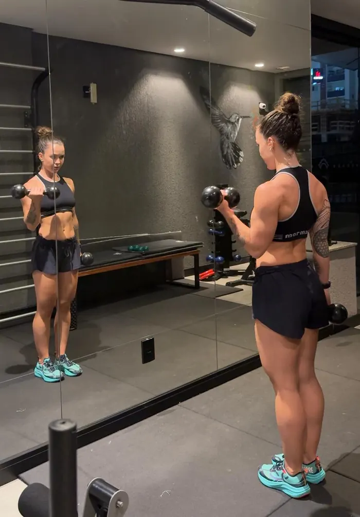 Paola treinando musculação com halteres